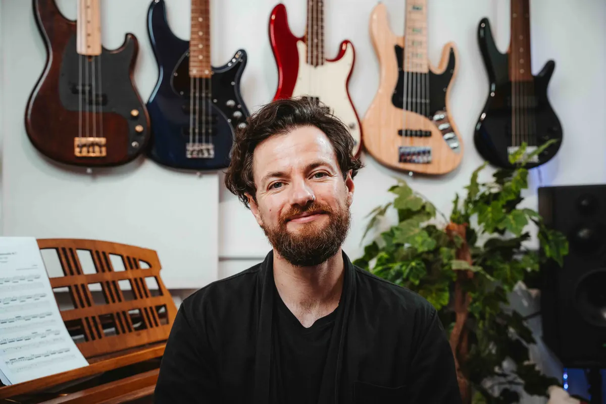 Jack in the studio with a wall of bass guitars